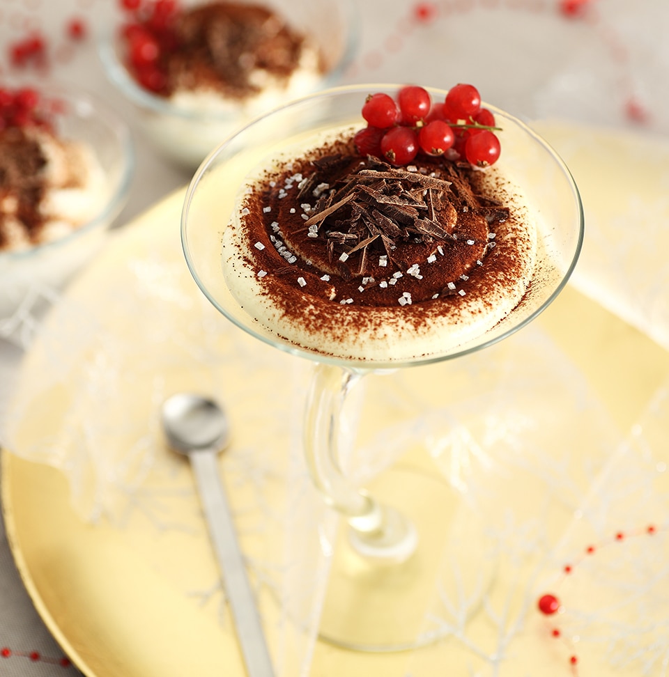 Tiramisù fatto in casa in un bicchiere guarnito con ribes